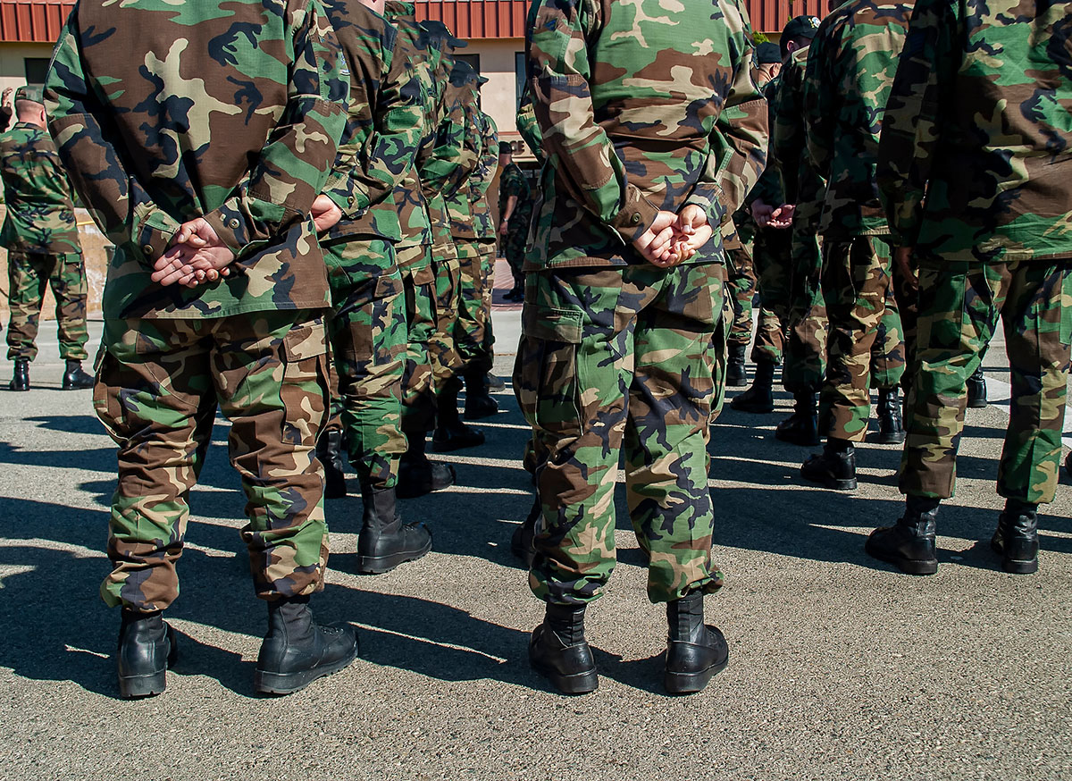 military men wearing camouflage uniforms standing in line